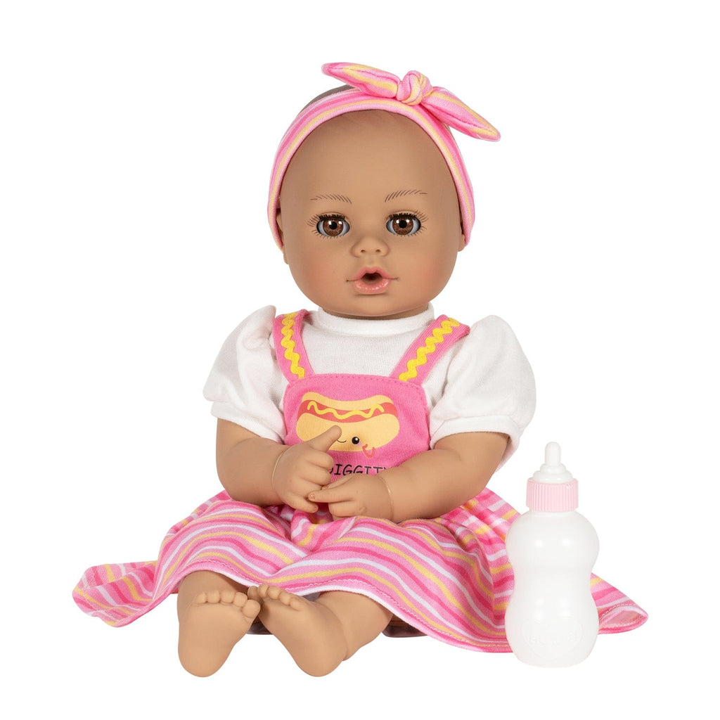 Adora Hot Diggity Dog baby doll set includes one 13-inch doll, a hot dog-printed one-piece dress with white undershirt, matching headband, white bloomers, and a pink baby bottle. Made for Ages 1+.