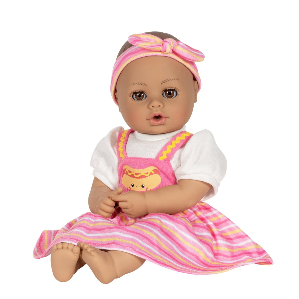 Adora Hot Diggity Dog baby doll set includes one 13-inch doll, a hot dog-printed one-piece dress with white undershirt, matching headband, white bloomers, and a pink baby bottle. Made for Ages 1+.