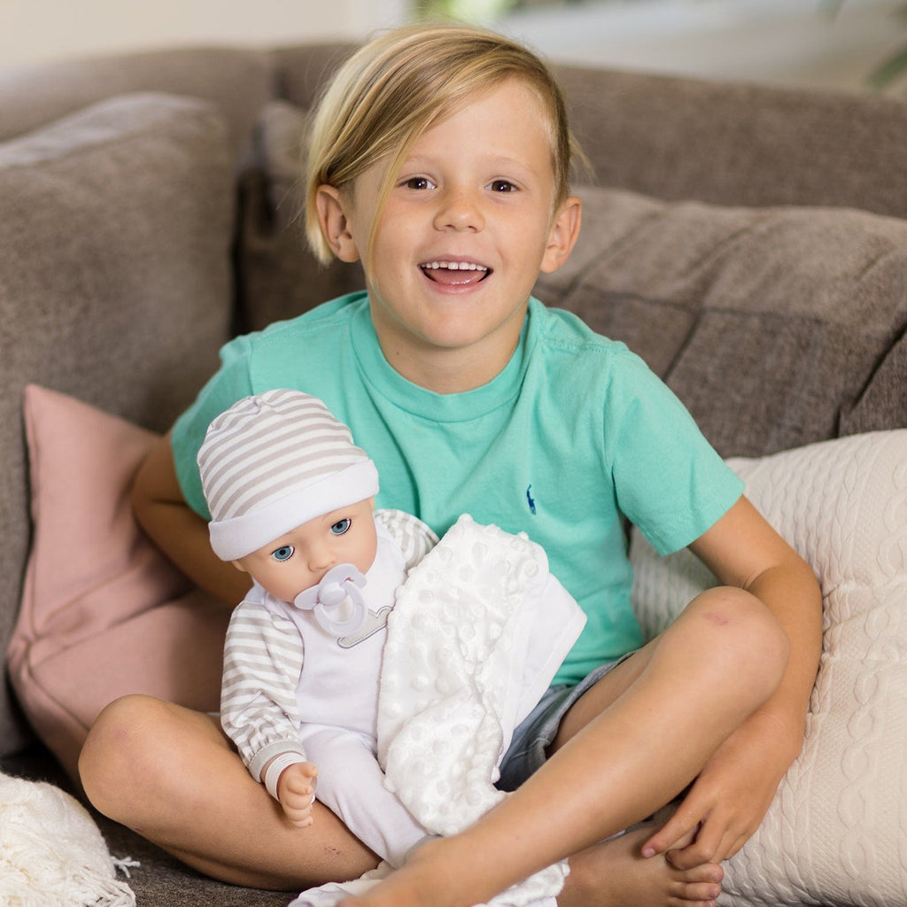 Gender-neutral baby doll set comes with one 16" weighted baby doll, a Certificate of Adoption, a pacifier, a hospital bracelet, a disposable diaper, a baby blanket, a crib, and a removable striped, cloud-print onesie with a matching cap.