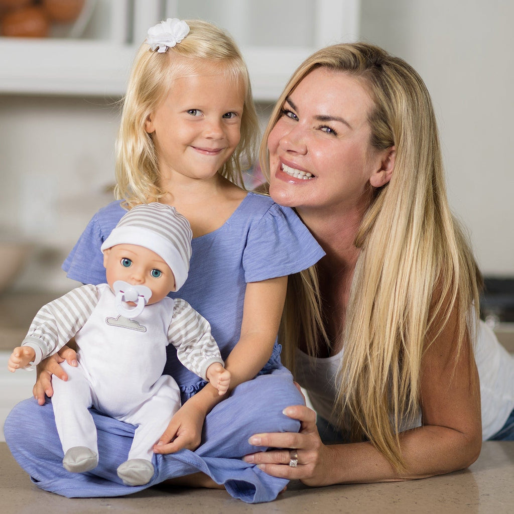 Gender-neutral baby doll set comes with one 16" weighted baby doll, a Certificate of Adoption, a pacifier, a hospital bracelet, a disposable diaper, a baby blanket, a crib, and a removable striped, cloud-print onesie with a matching cap.